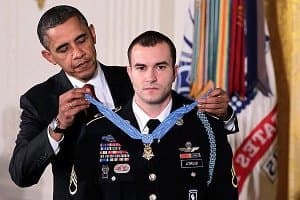 Барак Обама надевает на героя медаль